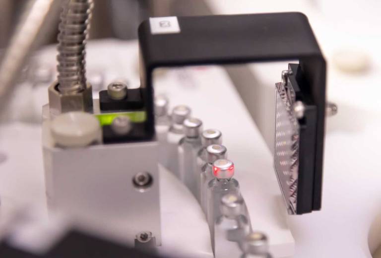 Pharmaceutical vials on automated conveyor undergoing quality inspection