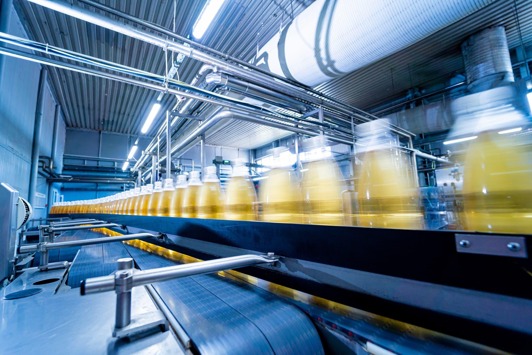 high‑speed beverage bottles moving along an automated production line in a modern facility