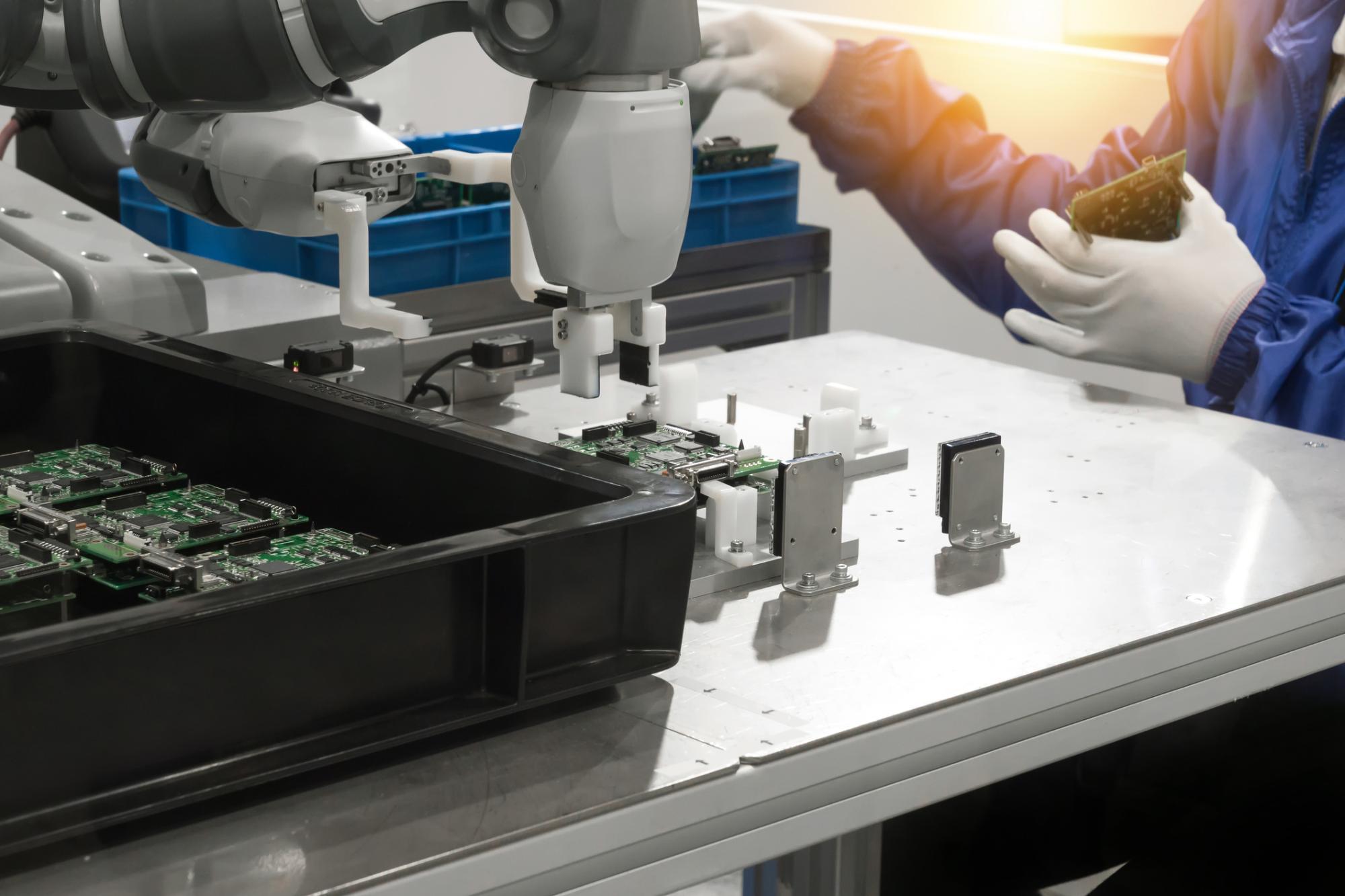 cobot and human working side by side assembling circuit boards in a clean electronics manufacturing environment